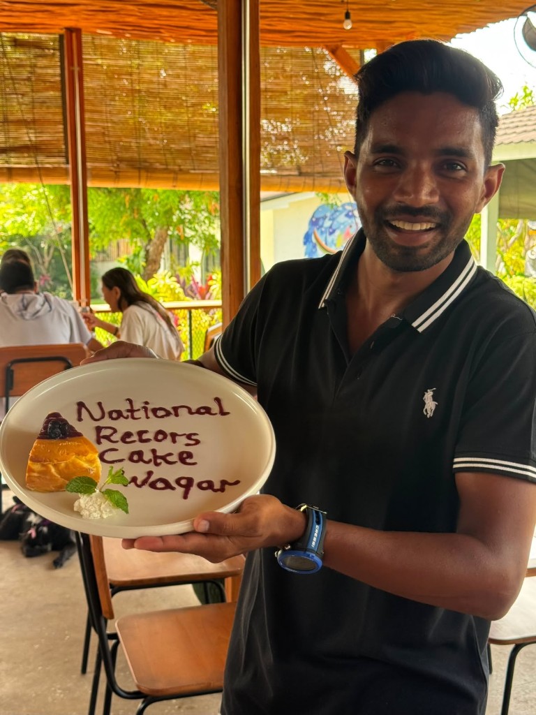 Waqar Khan holding a national records cake